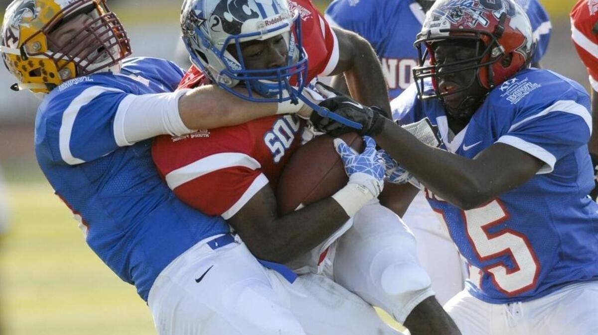 Abbeville’s Dubie DuBose and Calhoun County’s Rashad Riley wrestle down Airport’s Joshua Tucker in last year’s North-South All-Star Game.