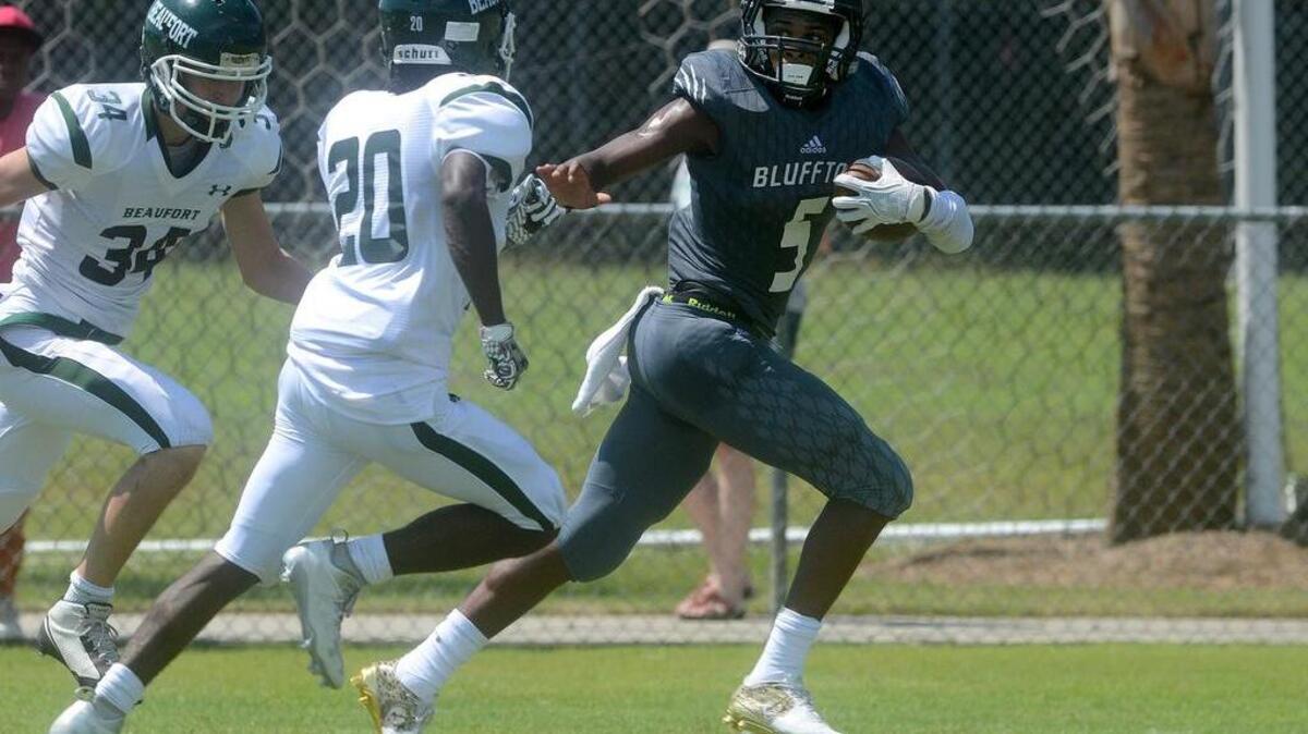 Bluffton’s Jermaine Patterson runs with the ball as Beaufort’s Kamren Spann and Cameron Makar try to tackle him during their game on Sept. 3 at Bluffton High School in Bluffton.
