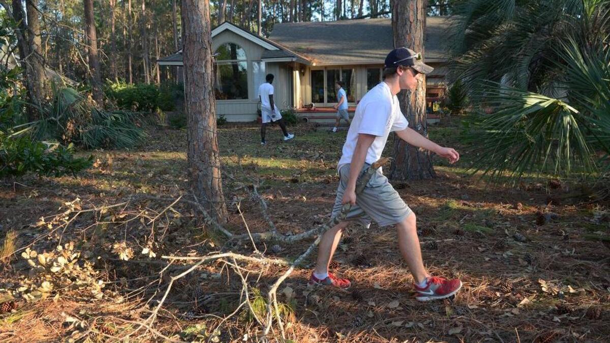 Hilton Head Island High School football player Garrett Nice joins teammates in clearing the yard of Hilton Head Plantation resident Corine Works of debris from Hurricane Matthew on Oct. 20. The Seahawks have been forgoing practice to assist islanders in need with their post-storm cleanup.