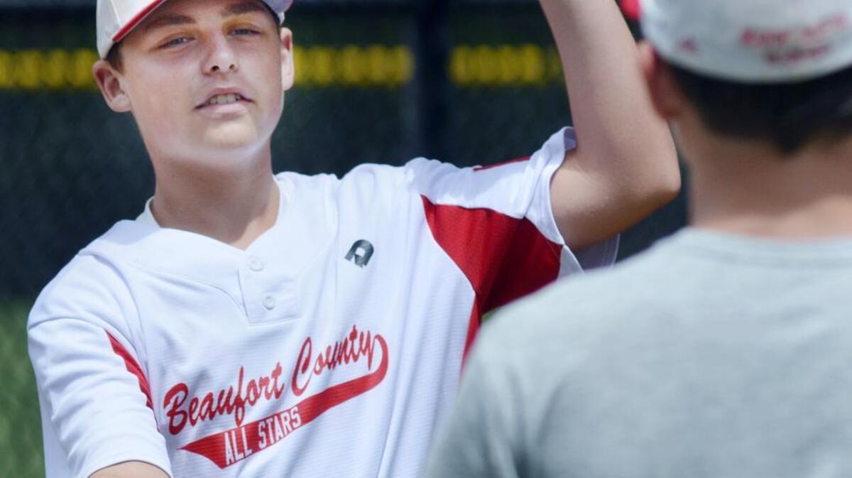 Niko Laing works on his hand-eye coordination by tossing baseballs with Beaufort County All Stars teammate Jaiden Hrobar on Tuesday as the team begins warmups before its game with Louisiana in the Dixie Boys World Series at Bluffton’s Oscar Frazier Park. Beaufort County won 17-10 and advances to the tournament’s championship round on Wednesday.