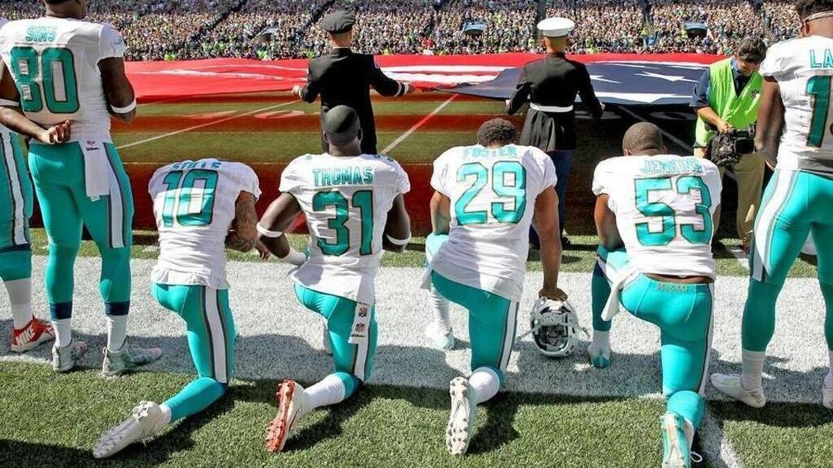 Miami Dolphins Jelani Jenkins, Arian Foster, Michael Thomas and Kenny Stills kneel in protest during the national anthem prior to their game against the host Seattle Seahawks on Sunday afternoon. CHARLES TRAINOR JR ctrainor@miamiherald.com
