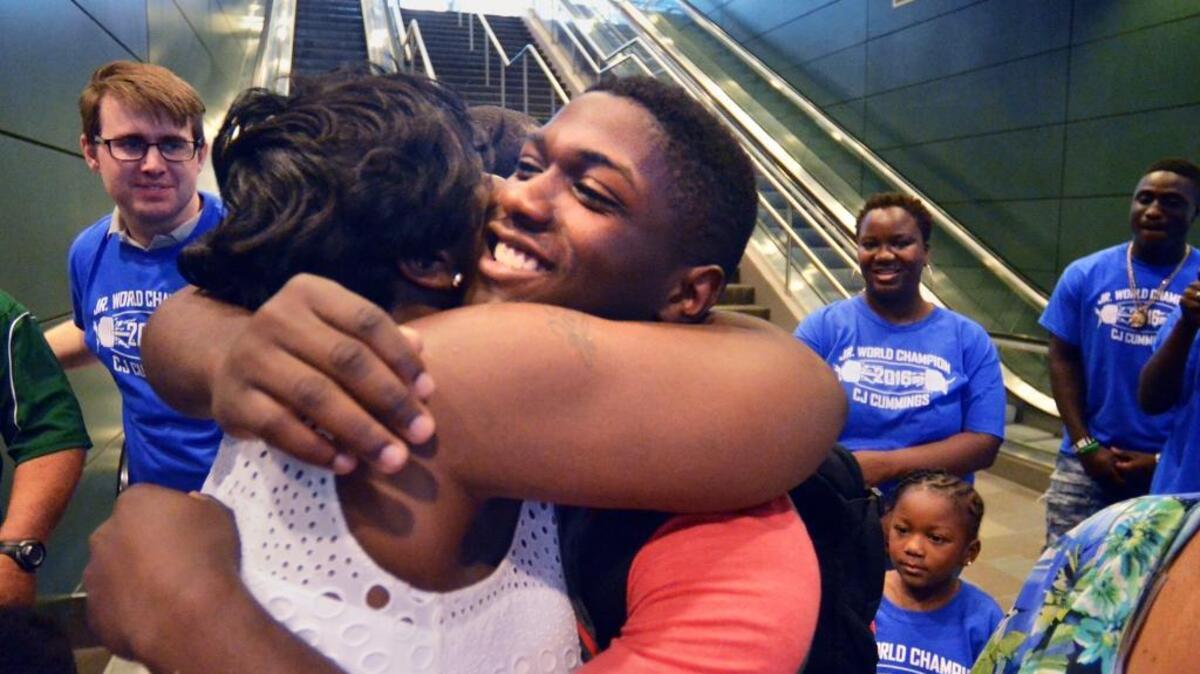 Beaufort weightlifter CJ Cummings was surprised by friends and family who came out to greet him upon his arrival at Savannah Hilton Head International Airport on July 2. Cummings, 16, was returning from the International Weightlifting Federation Junior World Championships in Tbilisi, Georgia, where he broke three world records en route to winning gold in the 69 kilogram (152 pounds) weight class. Here, he receives a big hug from cousin Shavon Coaxum.