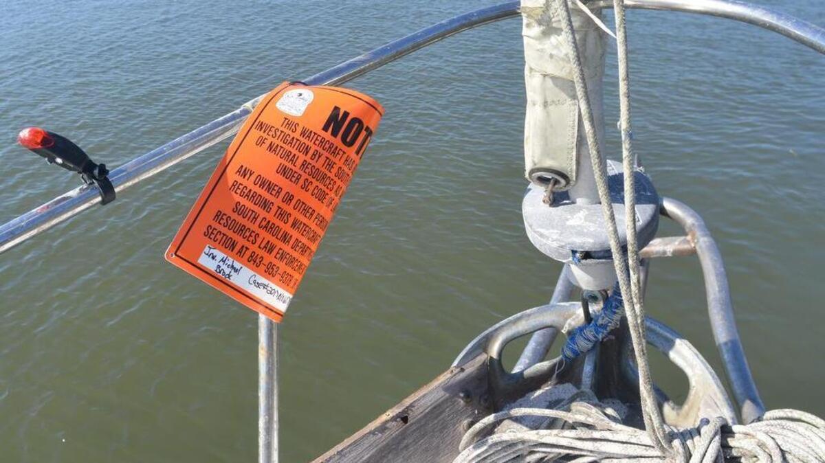 A SC Department of Natural Resources notice sign is attached to the front railing of the "Daydreamer," an abondoned vessel pulled from the Broad Creek by three Hilton Head Island residents. The three men are working with The Hilton Head Reef Foundation, a non-profit subsidiary of the Hilton Head Island Sportfishing Club, to raise funds for the hiring a professional diver for two sunken vessels, as well as the disposal costs of the boats.